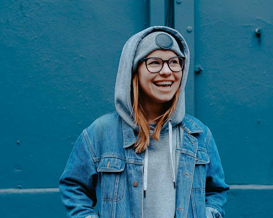 Smiling-Spokane-teen-standing-in-front-of-a-blue-wall-representing-youth-empowerment-through-Create-Your-Statement-programs Smiling Spokane teen standing in front of a blue wall, representing youth empowerment through Create Your Statement programs